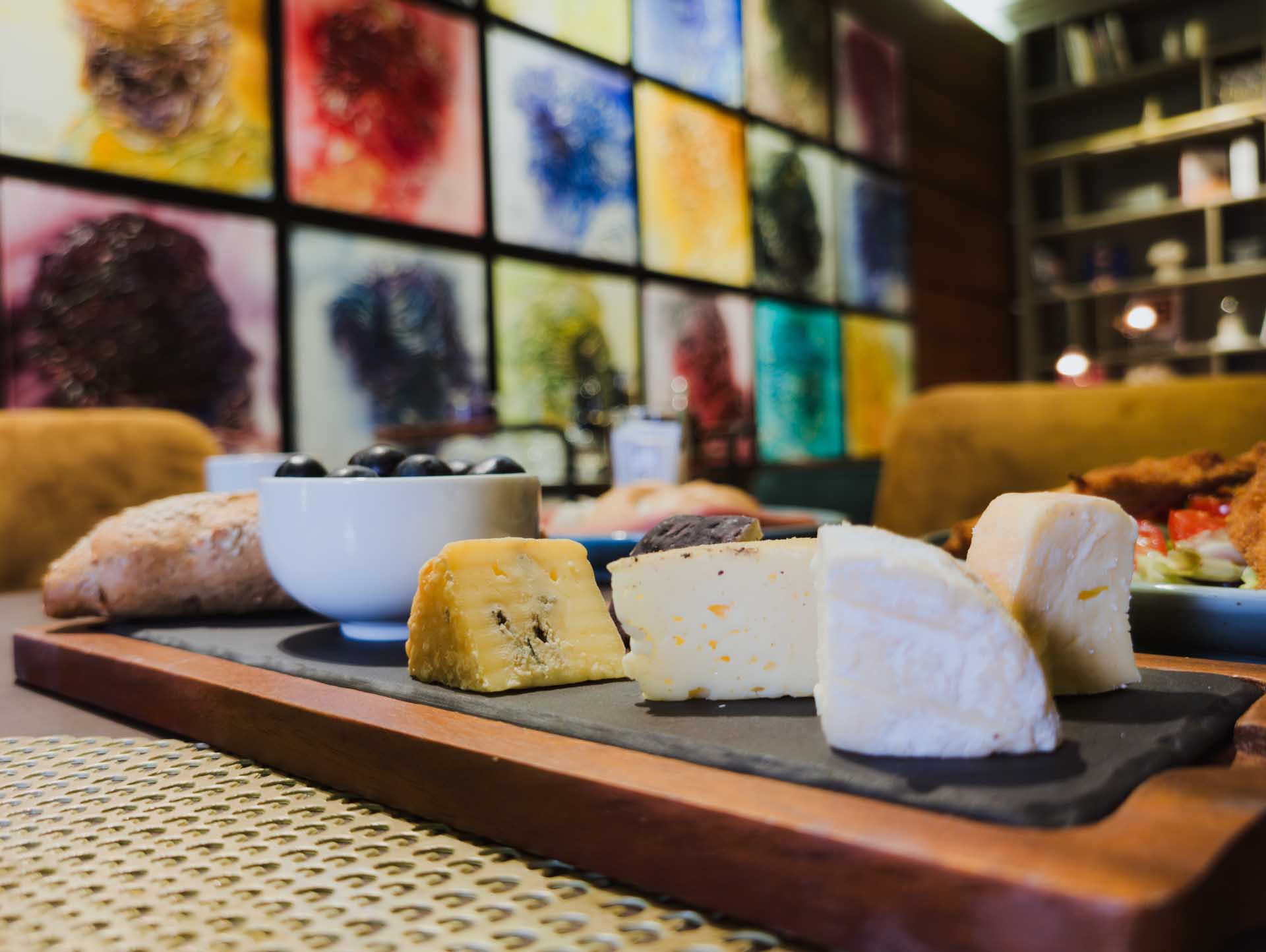 Selection of cheeses and fresh pastries on a serving board in the VIP lounge at Vienna Airport.